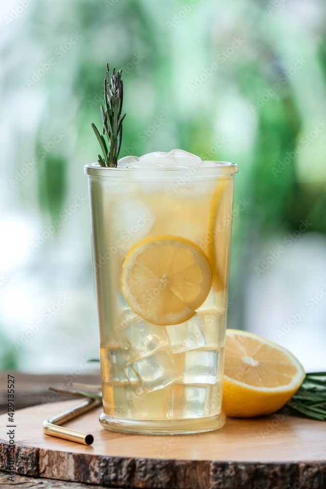 Glass of cold tea with rosemary and lemon on table outdoors Glass of cold tea with rosemary and lemon on table outdoors