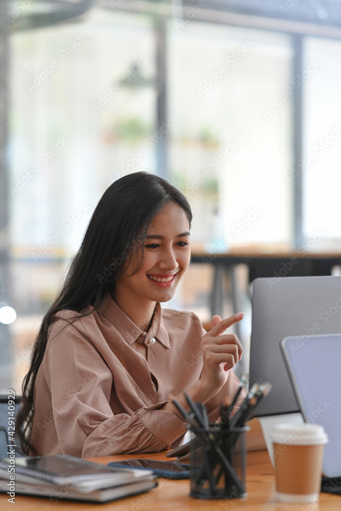 Smiling businesswoman talking on video conference with her colleagues on laptop computer. Smiling businesswoman talking on video conference with her colleagues on laptop computer.