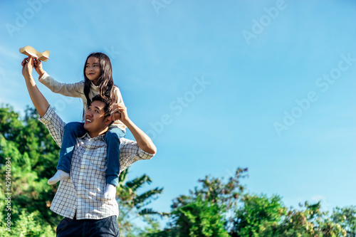 Daughter sits on his father's neck.The family enjoyed a holiday Holiday over beautiful nature.Concept People and family.