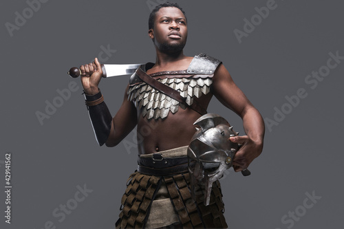 Violent gladiator with sword against gray background