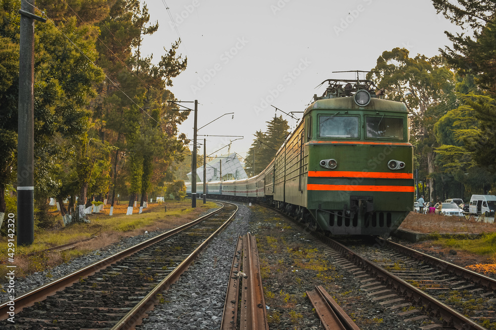 Train station in Batumi, Georgia, with train ready to depart from the station in early morning hours in a picturesque forest.