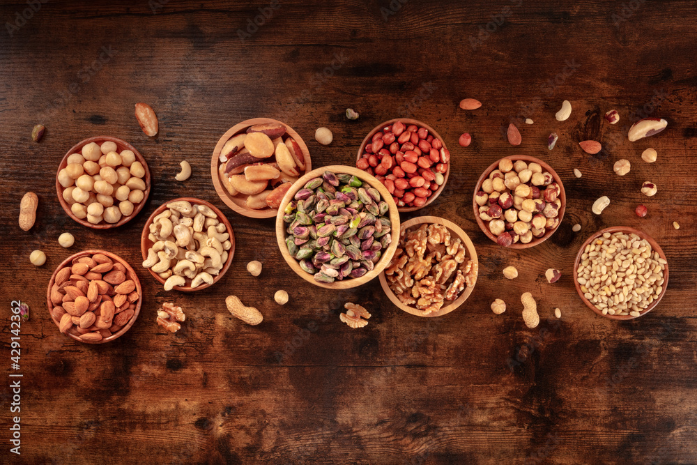 Various nuts, overhead flat lay shot on a wooden background Various nuts, overhead flat lay shot on a wooden background