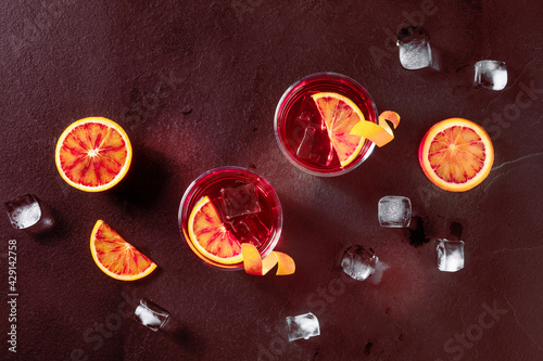 Negroni cocktails, toned image. Blood oranges, glasses with orange peel