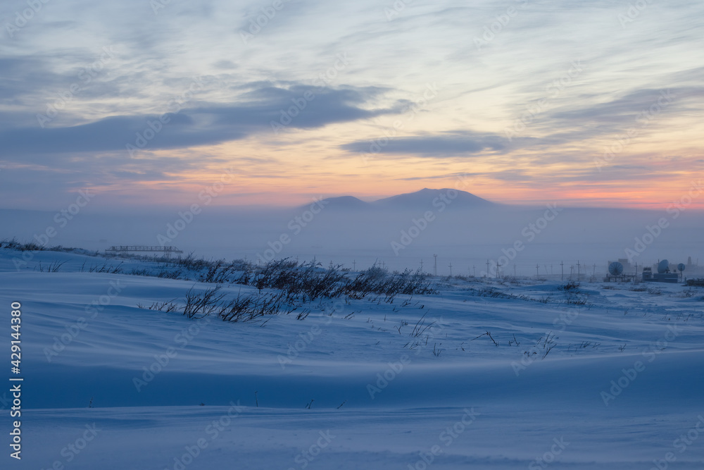 Winter arctic landscape. Polar twilight in the tundra. Cold frosty winter weather. Cold polar climate. In the distance, satellite dishes in the snowy tundra. Chukotka, Siberia, Far North of Russia. Winter arctic landscape. Polar twilight in the tundra. Cold frosty winter weather. Cold polar climate. In the distance, satellite dishes in the snowy tundra. Chukotka, Siberia, Far North of Russia.