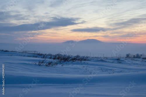 Winter arctic landscape. Polar twilight in the tundra. Cold frosty winter weather. Cold polar climate. In the distance, satellite dishes in the snowy tundra. Chukotka, Siberia, Far North of Russia. © Andrei Stepanov