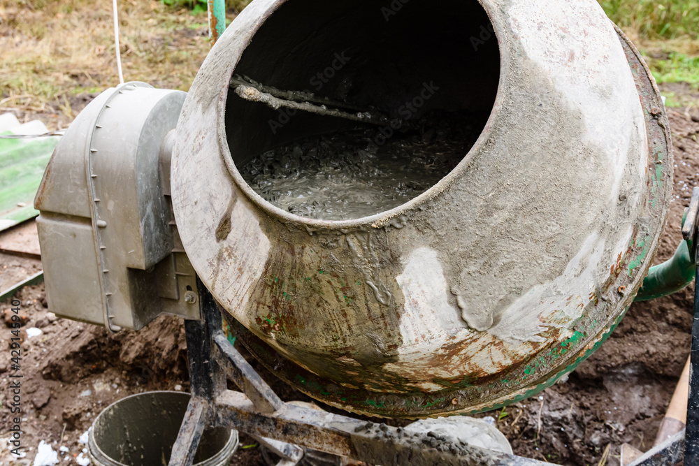 Preparing concrete in cement mixer for pouring foundation of the building Preparing concrete in cement mixer for pouring foundation of the building