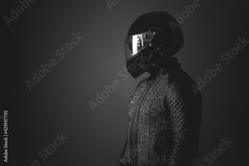 Motorbiker is looking aside on a dark background with a copy space. Side view. © Dmitriy