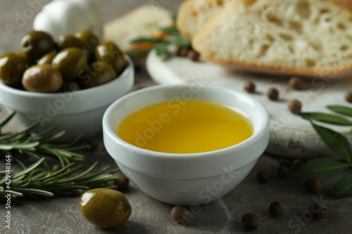 Concept of tasty eating with olive oil on gray textured table