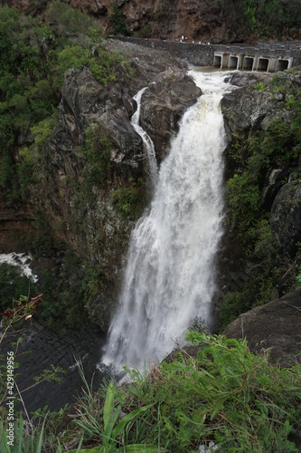 waterfall in the tropical forest of La Réunion, France by an old stone bridge