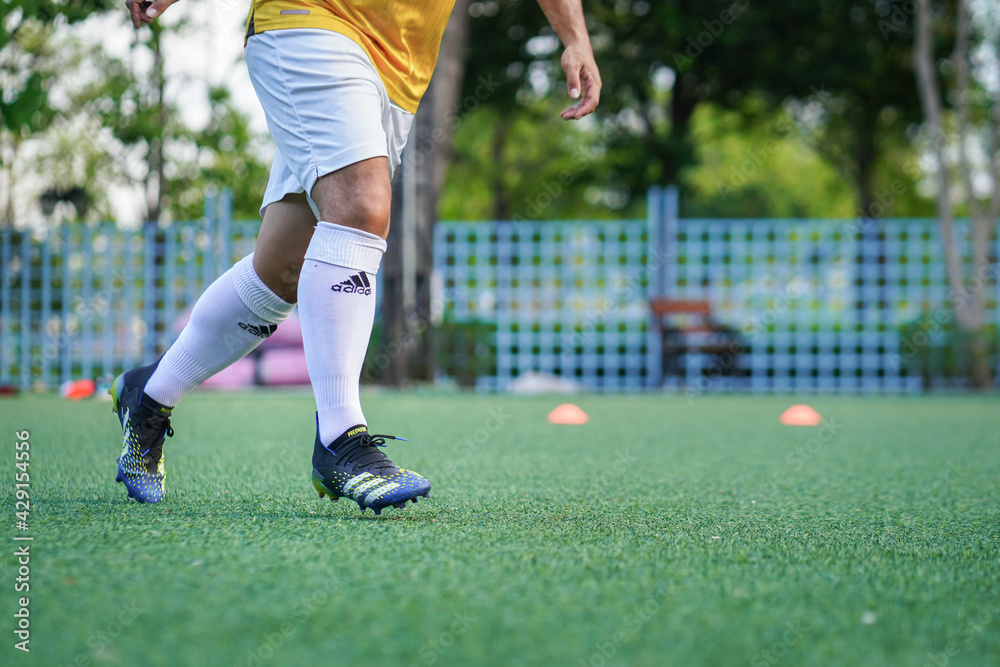 Bangkok, Thailand - April 2021: A football player who is wear Adidas  "Predator Freak.1", most famous control performance stud is training  football on local turf pitch. Selective focus. Stock Photo | Adobe Stock
