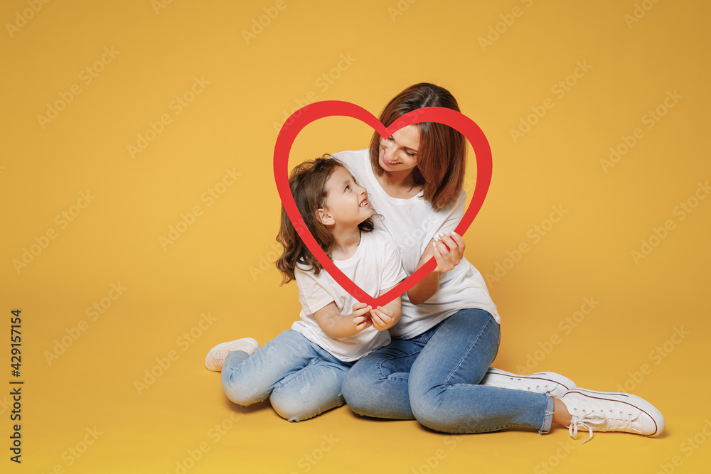 Full body length happy woman in basic white t-shirt have fun sit on floor child baby girl 5-6 years old Mom mum little kid daughter isolated on yellow color background studio Mother's Day love family. Full body length happy woman in basic white t-shirt have fun sit on floor child baby girl 5-6 years old Mom mum little kid daughter isolated on yellow color background studio Mother's Day love family.