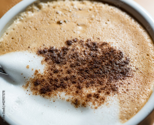 frothy cappuccino based on espresso coffee, warm milk cream and cinnamon