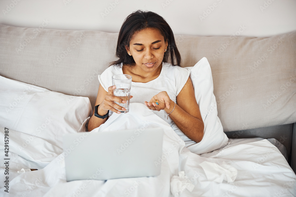 Charming young woman with flu taking pills at home Charming young woman with flu taking pills at home
