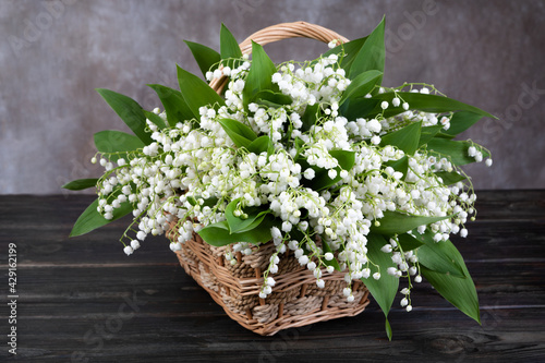 Obraz na płótnie lilies of the valley in a basket on the table w salonie