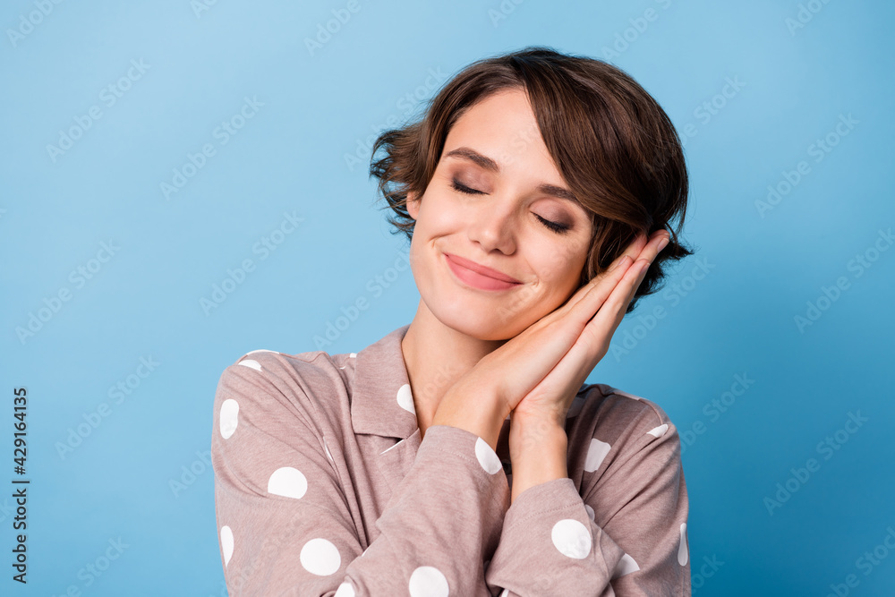 Photo of young beautiful attractive happy cheerful smiling dreamy girl sleeping isolated on blue color background Photo of young beautiful attractive happy cheerful smiling dreamy girl sleeping isolated on blue color background