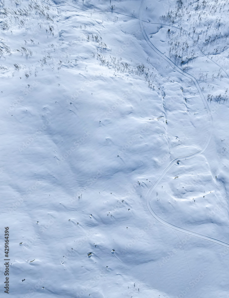 Snow covered arctic mountain terrain. Top down aerial view.