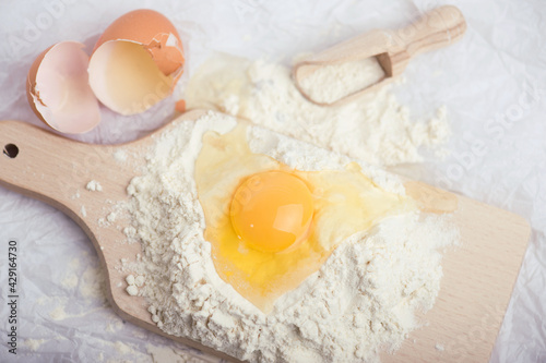 Flour and egg yolk on wooden cutting board