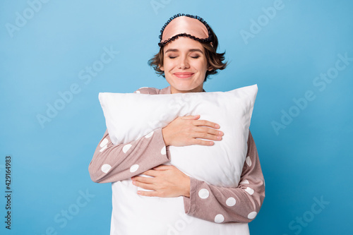 Photo of pretty lovely young woman enjoy sleep hold hug pillow soft isolated on blue color background