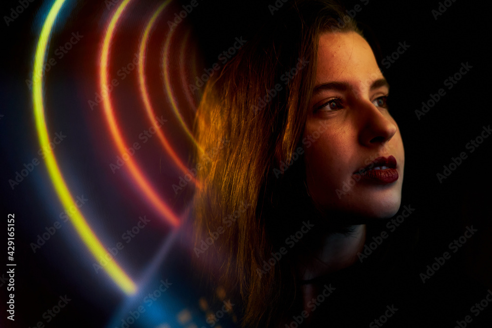 Pretty young woman with fair skin and long hair with colored neon and reflections. teenager with neon signs and reflections of colored neon lights. party woman Pretty young woman with fair skin and long hair with colored neon and reflections. teenager with neon signs and reflections of colored neon lights. party woman