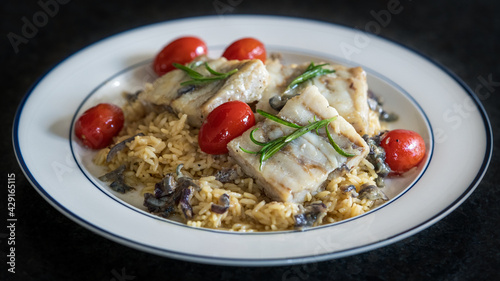 ready to eat - roasted trout fillet with rice and cherry tomatoes, onions, rosemary in olive oil