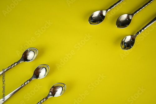 silver ware sppon on bright yellow background photo