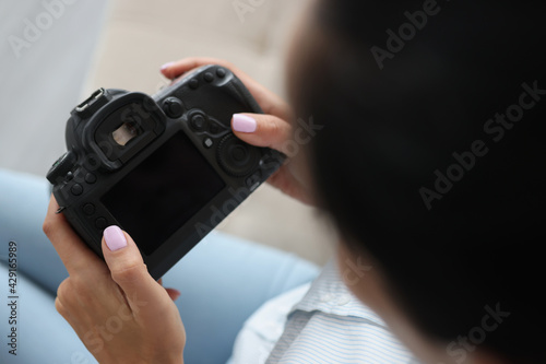 Woman holding black camera in her hands closeup