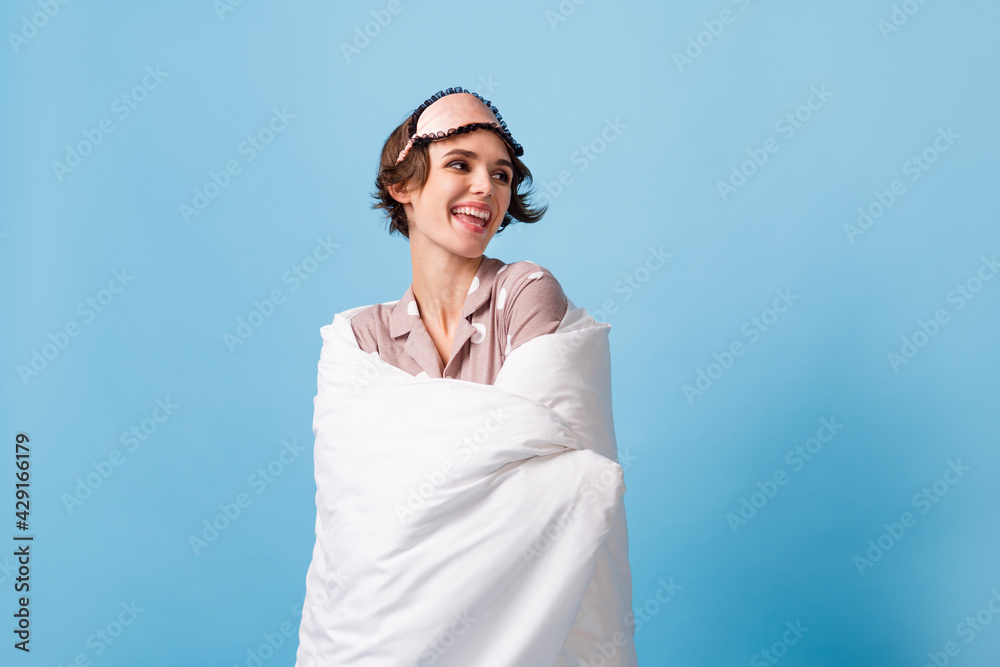 Photo of lovely attractive woman wrapped in blanket look empty space good mood isolated on blue color background Photo of lovely attractive woman wrapped in blanket look empty space good mood isolated on blue color background
