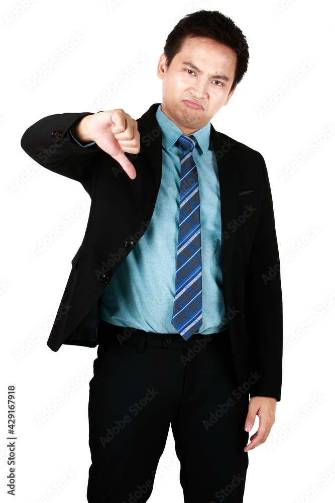 Portrait of Young Asian man smiling standing wearing black suit and pointing thumbs down isolated on a white background. Concept businessman with angry face, negative sign showing dislike rejection. Portrait of Young Asian man smiling standing wearing black suit and pointing thumbs down isolated on a white background. Concept businessman with angry face, negative sign showing dislike rejection.