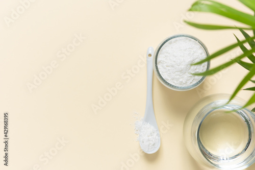 Collagen powder and a glass of water on a beige background with a copy space. Extra protein intake