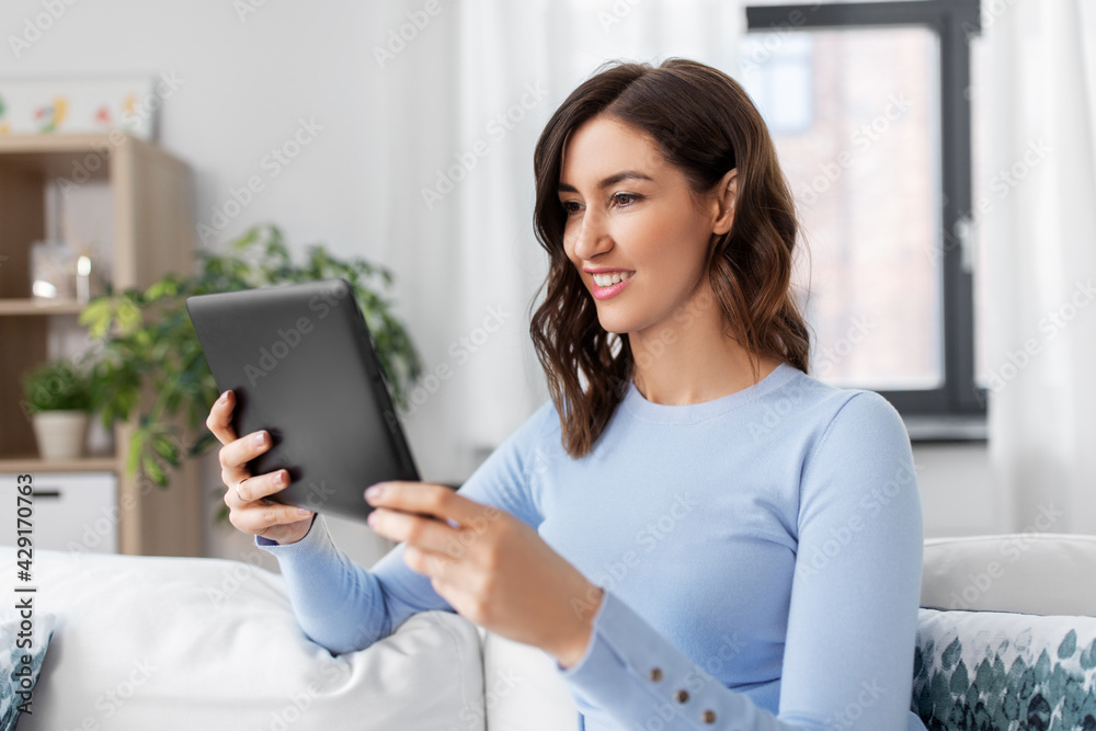 people, technology and leisure concept - happy young woman with tablet pc computer at home people, technology and leisure concept - happy young woman with tablet pc computer at home