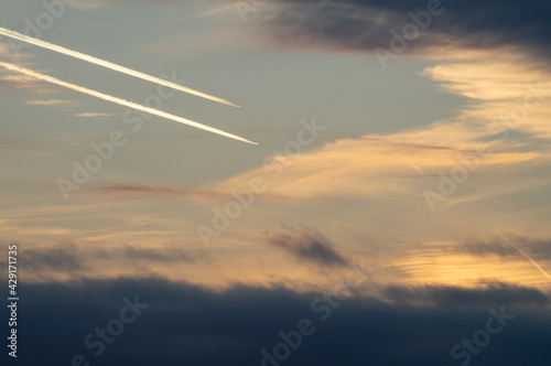 airplane tracks on the sky clouds sunset orange