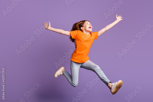 Full length body size view of attractive crazy cheerful girl jumping going having fun isolated over violet purple color background