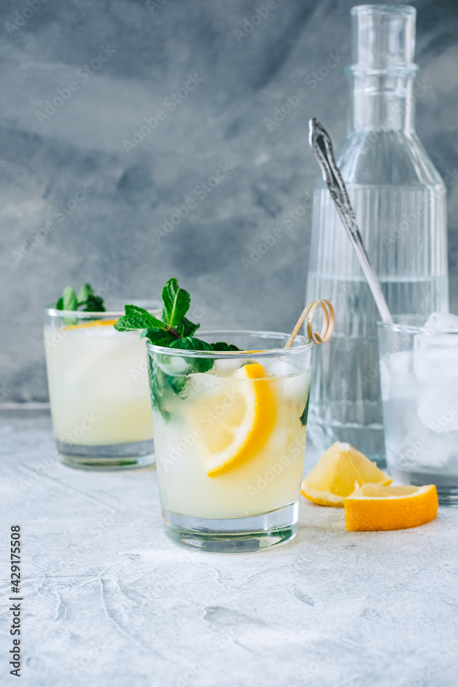 Fototapeta premium Ice lemonade in glass with lemon pieces, fresh mint and ice cubes.