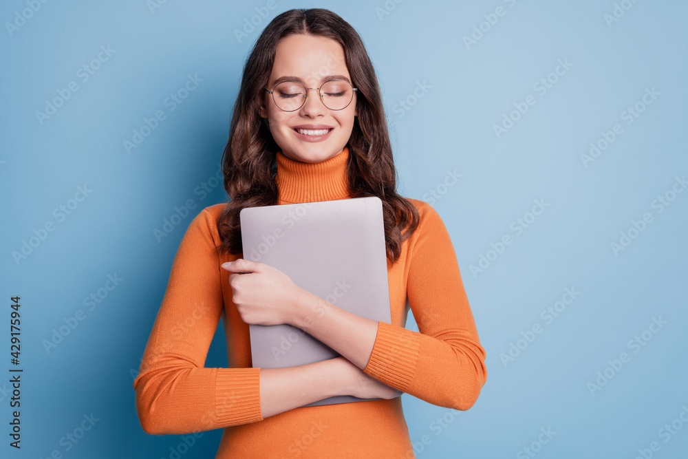 Photo of peaceful woman hug tablet closed eyes dream posing on blue background Photo of peaceful woman hug tablet closed eyes dream posing on blue background