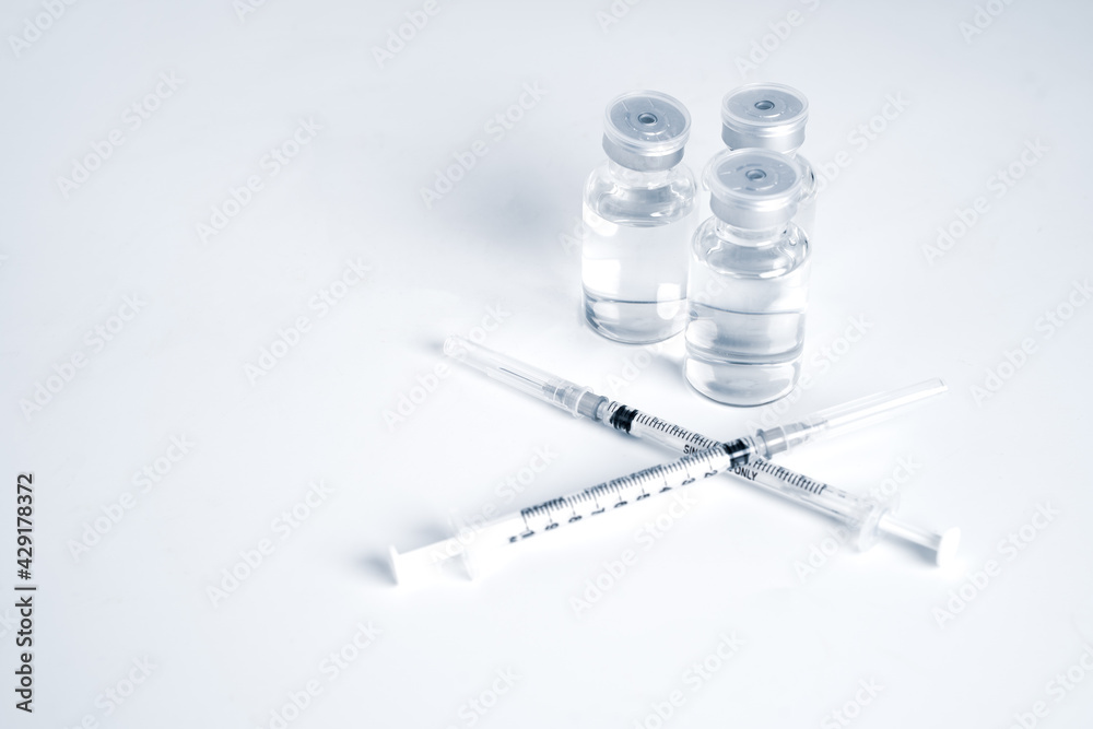 Empty bottle of vaccine with syringe for hygiene injection. Pharmaceutical equipment protective infection of pandemic covid-19 virus, flu, disease. Isolated on white background, copy space. Empty bottle of vaccine with syringe for hygiene injection. Pharmaceutical equipment protective infection of pandemic covid-19 virus, flu, disease. Isolated on white background, copy space.