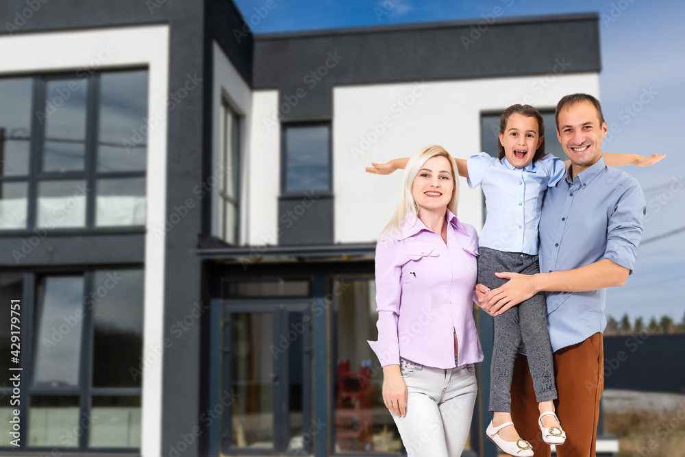 Happy family near new house. Real estate concept.