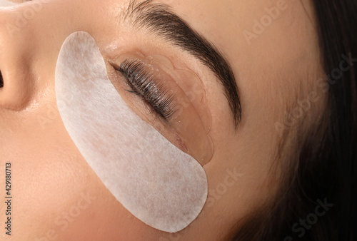 Young woman undergoing eyelash lamination, closeup. Professional service photo