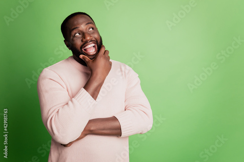 Photo of excited clever man finger chin look empty space wear white shirt over green background photo