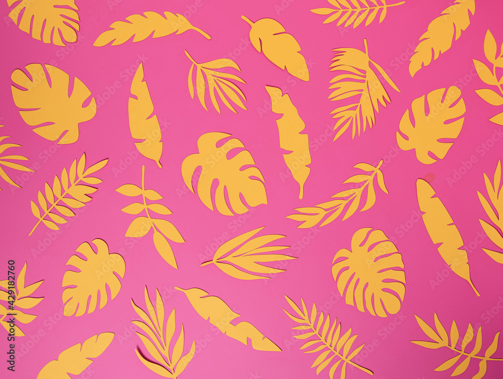Fototapeta premium Natural tropical pattern with yellow paper palm leaves on pastel pink background. Minimal summer exotic texture concept. Flat lay, top view.