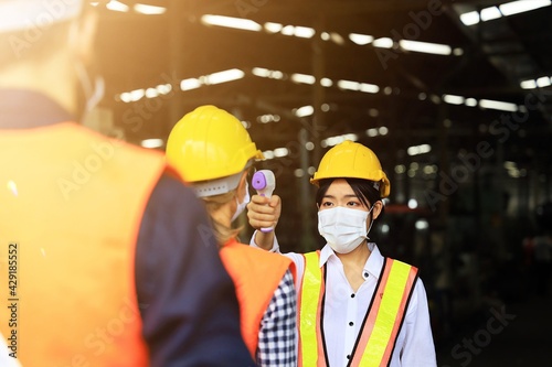 workers wearing surgical mask in warehouse. © Mallika