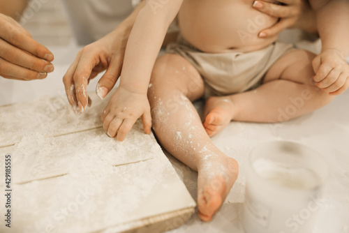 The bare legs of a small child in flour