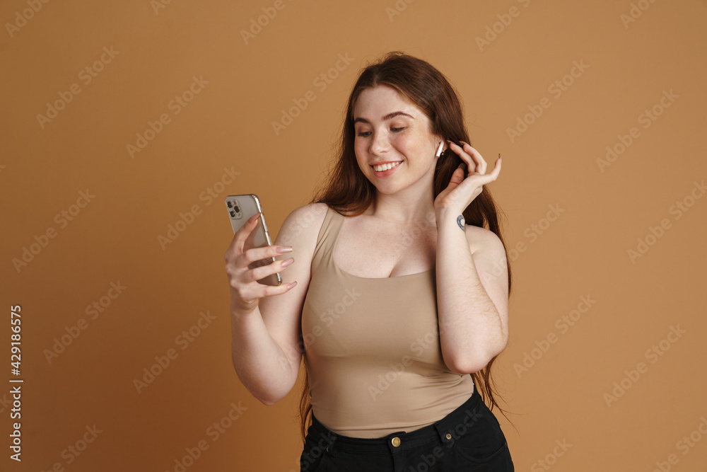 Young smiling woman using mobile phone and earphone Young smiling woman using mobile phone and earphone