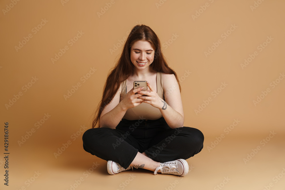 Smiling young plus size woman holding mobile phone Smiling young plus size woman holding mobile phone