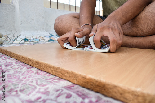 A Gambler playing and dividing playing cards on wooden plank image background  