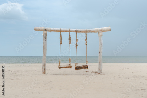 lonely wooden swing on the beach