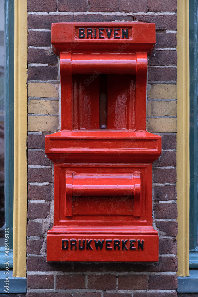 Obraz premium Old red postbox mounted in a brick wall of a house with the text BRIEVEN (letters) and DRUKWERKEN (press-work or printed matter) in Deventer, the Netherlands