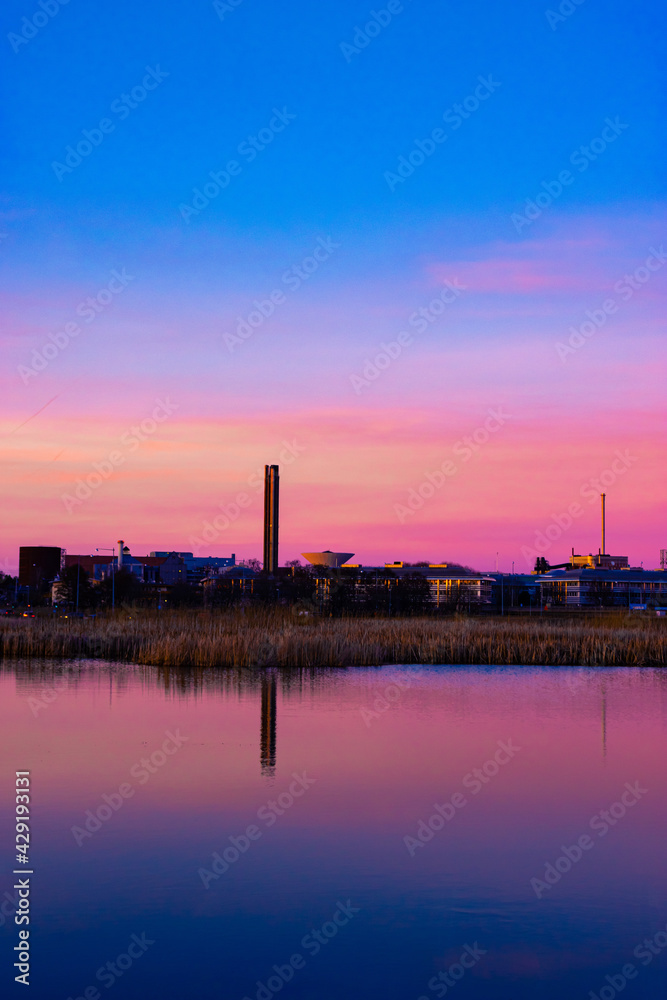 sunset over the city with many industry buildings and factories. 