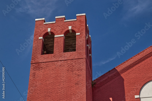 Fototapeta Naklejka Na Ścianę i Meble -  Red brick tower with window openings blue sky