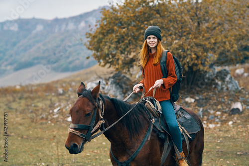 woman hiker with a backpack rides a horse in the mountains nature travel © SHOTPRIME STUDIO