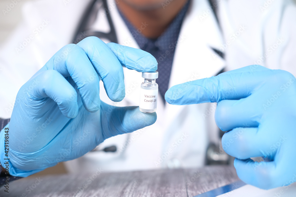 hand in latex gloves holding glass ampoule vaccine, with copy space hand in latex gloves holding glass ampoule vaccine, with copy space
